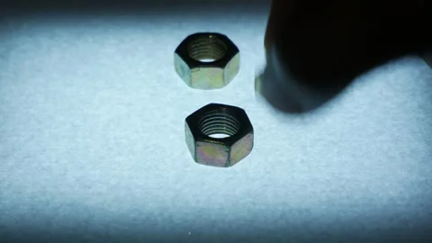 Hand Picking Up Metal Hex Nut from Textured Surface Stock Footage 340069441