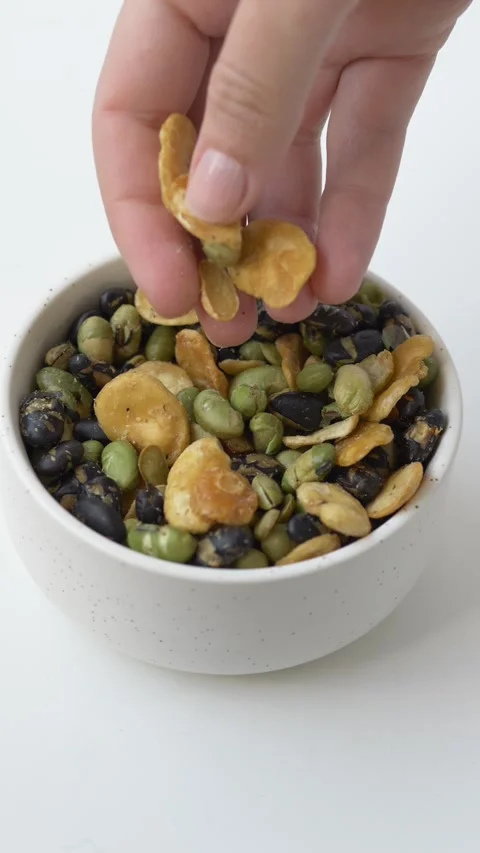 Hand picking mixed beans from white bowl, rich in natural protein and fiber Stock Footage 331010344