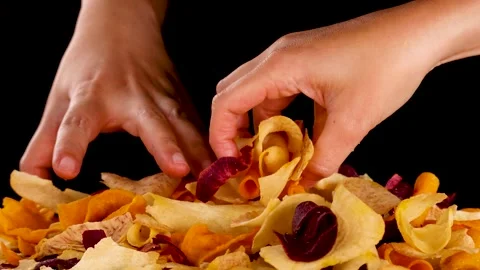 Hand Picking Mixed Root Vegetable Chips Against Black Background Stock Footage 321040811