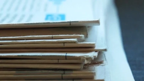 Hand picking up newspaper from a pile Stock Footage 116047540