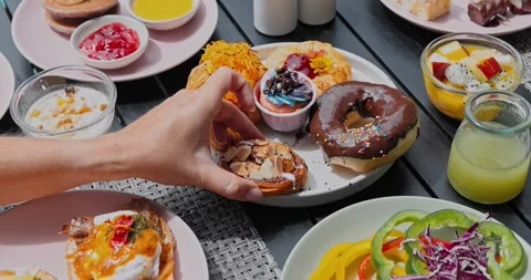 Hand picking up pastry from breakfast table Video stock 332775289