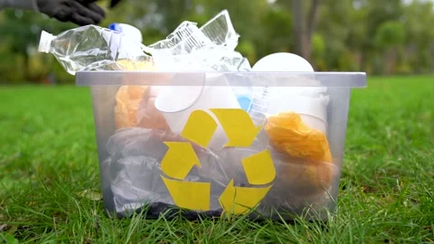 Hand picking up plastic trash from grass and put it in box with recycle logo. Stock Footage 143144418