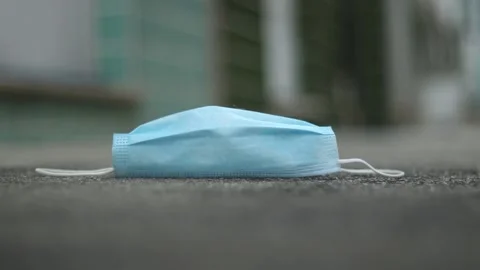 Hand picking up a protective mask on the floor Stock Footage 158586520