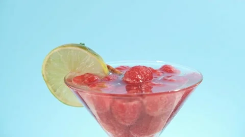 Hand picking a Raspberry cocktail Summer drink on cyan Stock Footage 244767659