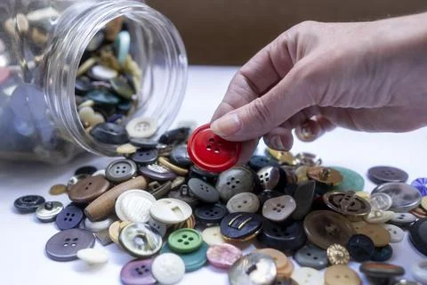 Hand Picking Red Button from Pile Stock Photos