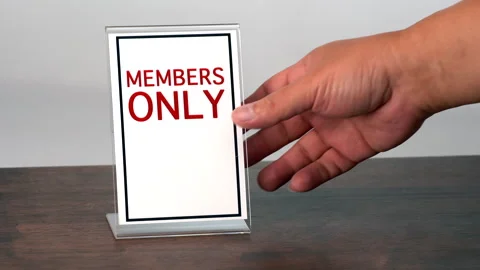 A hand is picking up a sign for member only on a wooden table. Stock Footage 314575551