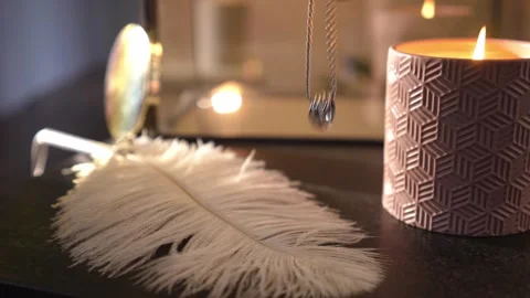 Hand picking up a silver necklace by a candle Stock Footage 328006549
