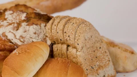 Hand Picking Up Slice of Fresh Multigrain Bread from Bakery Assortment Stock Footage 337768946