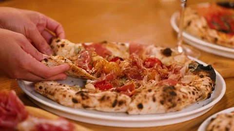 Hand Picking Up Slice of Neapolitan Pizza with Prosciutto and Tomatoes Stock Footage 337691068