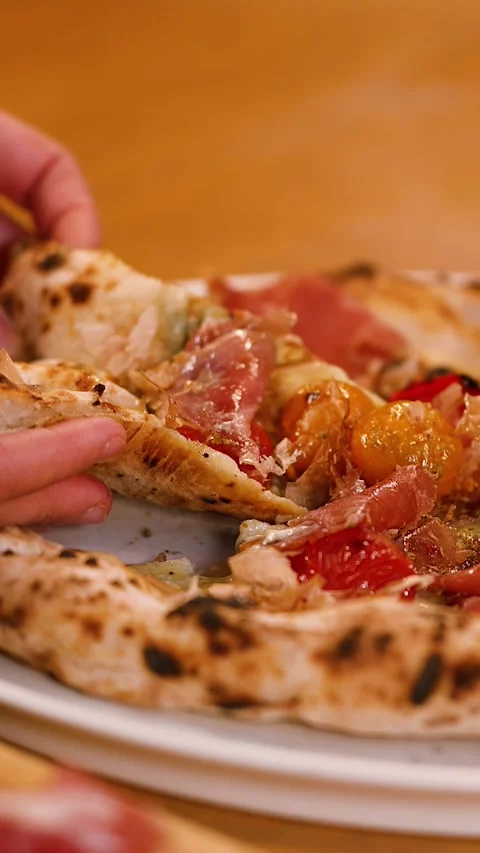Hand Picking Up Slice of Neapolitan Pizza with Prosciutto and Tomatoes Stock Footage 337771055