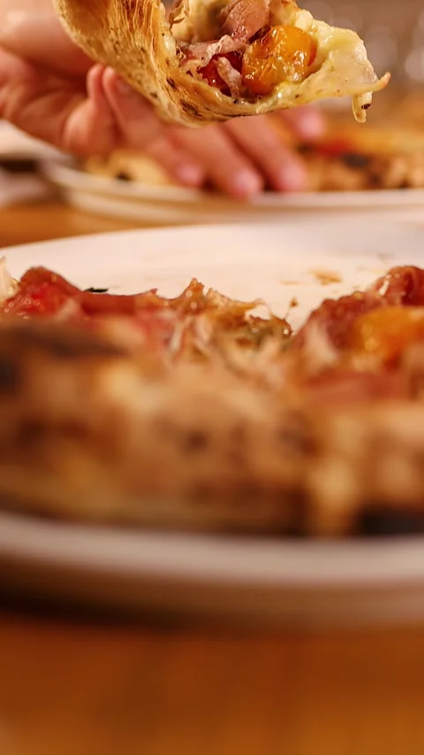 Hand Picking Up Slice of Neapolitan Pizza with Prosciutto and Tomatoes Stock Footage 337875311