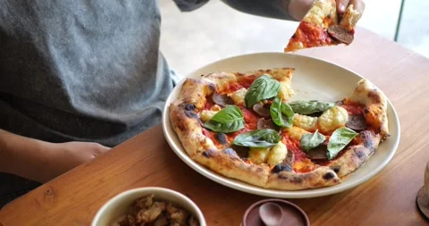 A hand picking a slice of vegan peperoni pizza Stock Footage 279814074