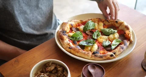 A hand picking a slice of vegan peperoni pizza 库存影片 279814130