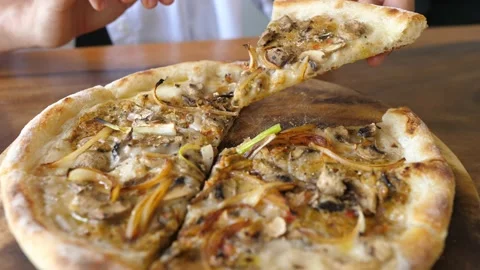 A hand picking a slice of vegan pizza topped with lots of dairy free cheese Stock Footage 153388302