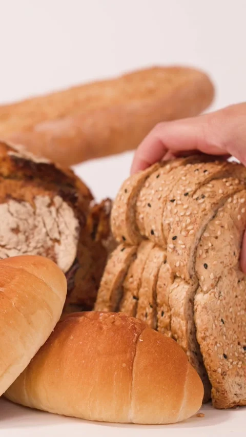 Hand Picking Up Sliced Multigrain Bread From Assorted Bakery Display Stock Footage 337227086