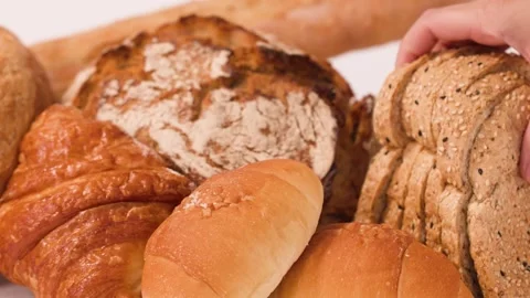Hand Picking Sliced Multigrain Bread from Assorted Fresh Bakery Products Stock Footage 337519447