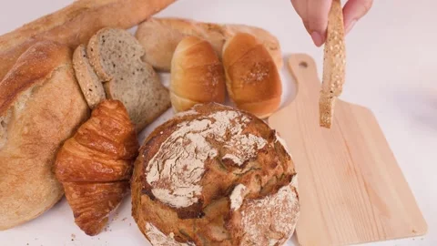 Hand Picking Sliced Multigrain Bread from Assorted Bakery Display Stock Footage 337533056