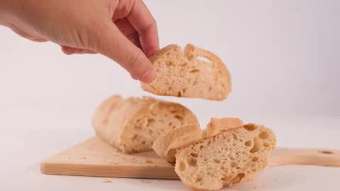 Hand Picking Up Sliced Sourdough Bread From Wooden Board Stock Footage 337227080