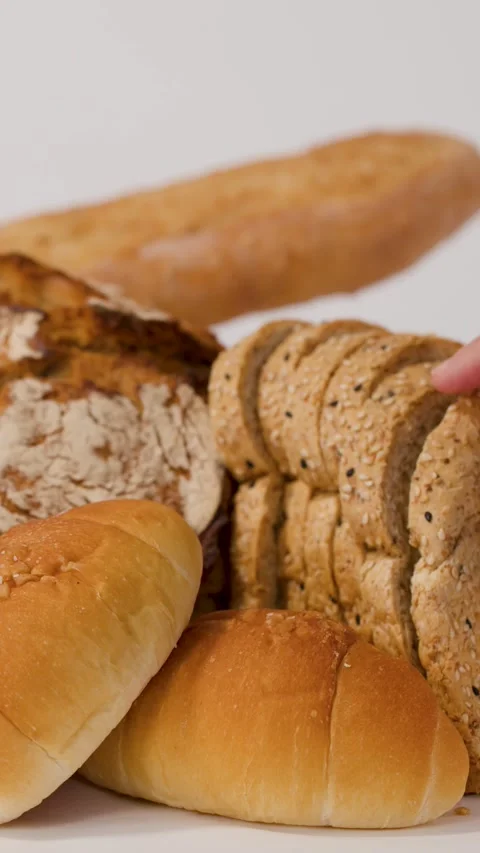 Hand Picking Up Sliced Whole Wheat Bread From Assorted Bakery Display Vídeo Stock 337535461