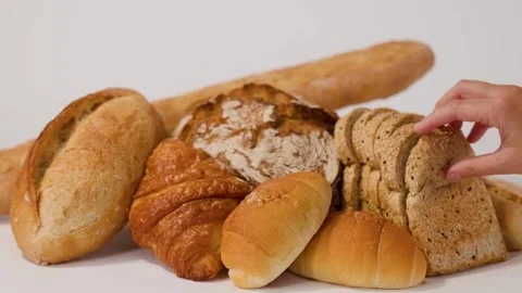 Hand Picking Up Sliced Whole Wheat Bread from Bakery Assortment Stock Footage 337767965