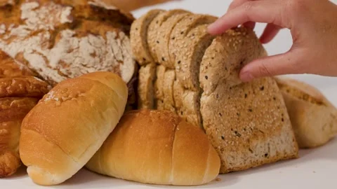 Hand Picking Up Sliced Whole Wheat Bread From Bakery Assortment Stock Footage 337877145