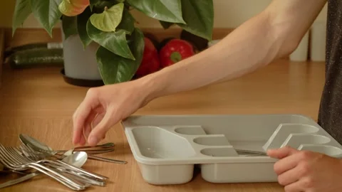 Hand picking spoon from table. Unrecognizable person sorting cutlery near Stock Footage 316307692