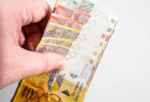 Hand Picking Up a Stack of Swiss Franc Notes Stock Photos