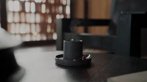 Hand picking up a steaming cup of coffee Video stock 339471958