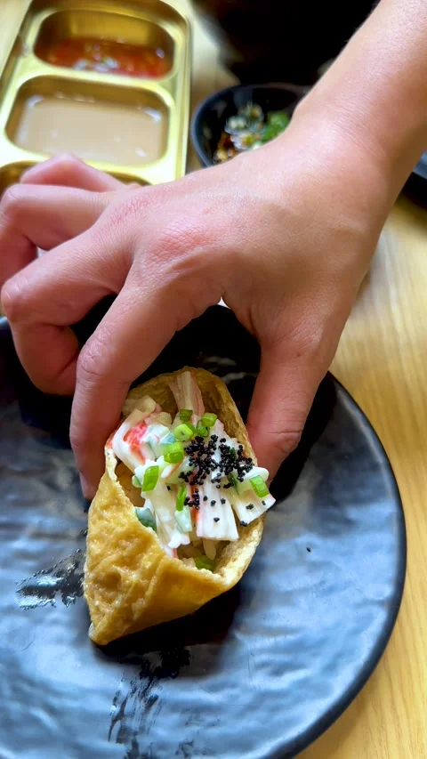 Hand Picking Up Sushi Inari Roll With Seafood Salad Filling 動画素材 321672503