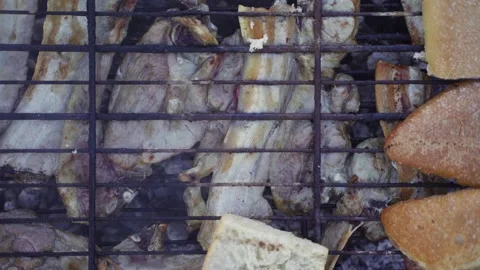 Hand picking toasted bread from barbecue grill with meat over charcoal Stock Footage 181879747