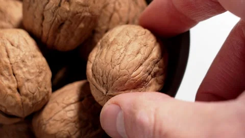 Hand picking walnut from ceramic kitchen bowl Stock Footage 330420750