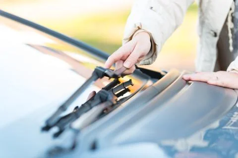 Hand picking up windscreen wiper Stock Photos