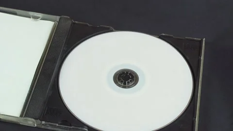 Hand picks up and installs a white CD DVD disc in a plastic box. Stock Footage 137591263
