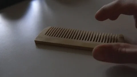 Hand picks up and puts the comb on the table Stock Footage 107598820
