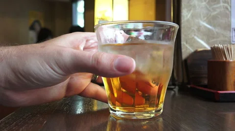 Hand Picks Up And Puts Down Glass Of Plum Wine With Ice At Tokyo Restaurant Video stock 51888823