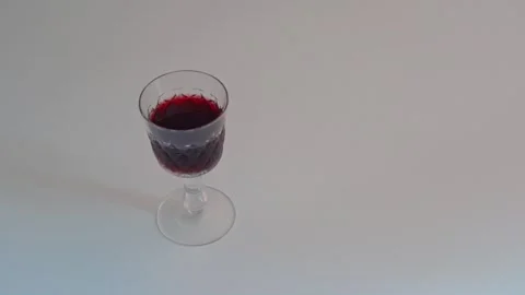 A hand picks up and returns a partially bitten red apple next to a glass of red Stock Footage 310763716