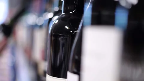 A hand picks up a bottle of wine from the store shelf Stock Footage 187130553