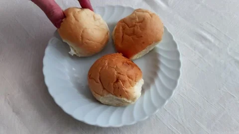 Hand Picks Bread Roll from White Plate on Soft Tablecloth Surface 스톡 동영상 326653743