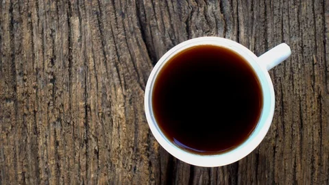 Hand picks up a cup of coffee from the table, top view. Stock Footage 115704984