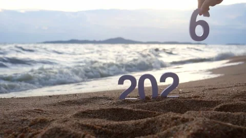 Hand picks out the number 5, changing from year 2025 to 2026 on the beach Stock-Footage 321414744