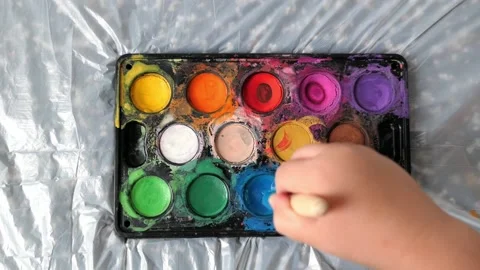 Hand picks up paint with a brush top view Stock Footage 156675779