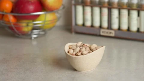 A hand picks pistachios from the plate on the table Stock Footage 267936859