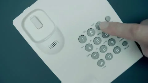 Hand picks up the receiver of a white push-button old telephone, dials a number Stock Footage 287932253