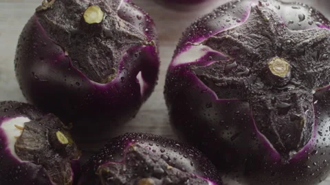 HAND PICKS UP A ROUND EGGPLANT Stock Footage 132535514