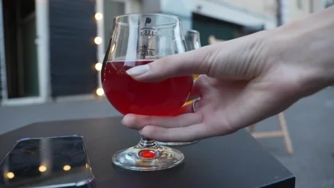 Hand picks up a sour red beer in a glass Stock Footage 280437659