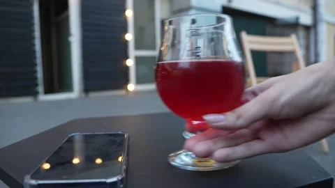 Hand picks up a sour red beer in a glass Stock Footage 281343639