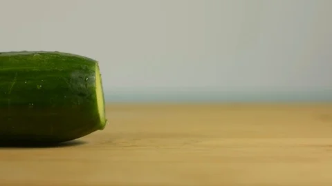 Hand picks the tail of the cucumber from the table Stock Footage 128917709