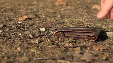 Hand picks up wallet from the ground 스톡 동영상 167930662