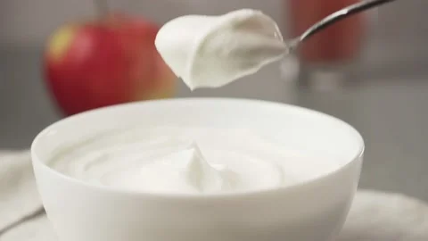 Hand picks up yogurt with a spoon. Stock Footage 163447550