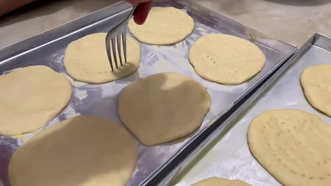 Hand pierces pizza dough with a fork to ensure a flat. Stock Footage 320503884